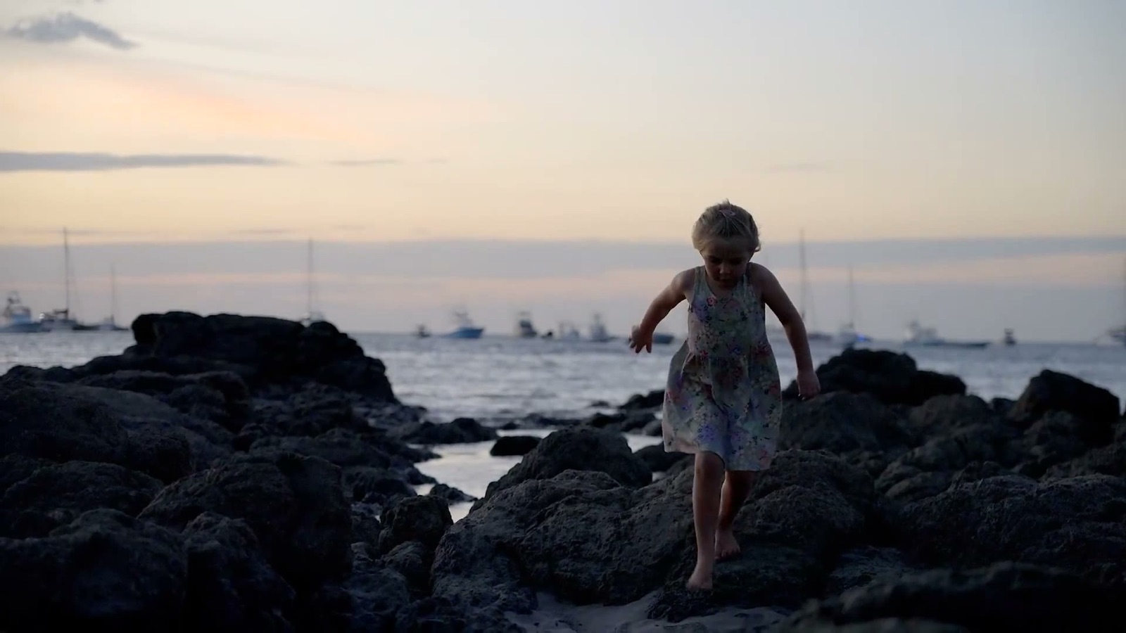 Shanti climbing beach rocks at sunset in Tamarindo, Costa Rica